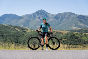 Una chica joven descansando en la carratera después de pedaleara intensamente gracias a los ejercicio de pedaleo.