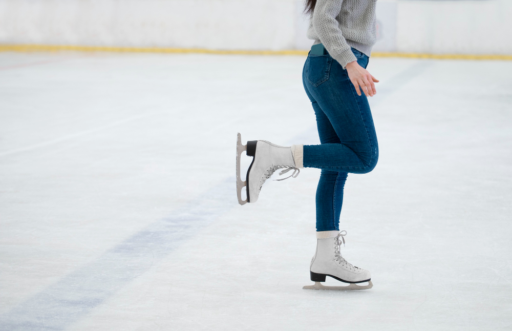 Una chica en patines de hielo practicando 10 ejercicios para mejorar su equilibrio en el patinaje de hielo