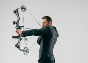 Un tirador utilizando un arco de poleas y precisión como parte de los tipos de arco en el tiro